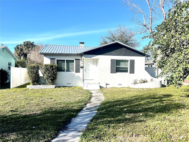 bungalow-style house with a front lawn, fence, stucco siding, metal roof, and crawl space