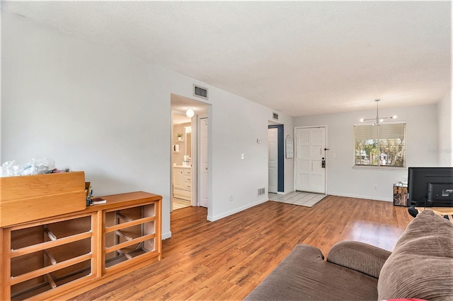 living room with a textured ceiling and light hardwood / wood-style floors