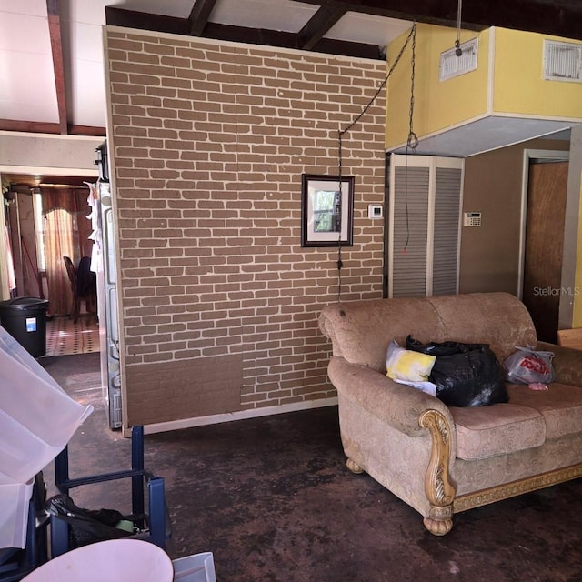 living room with beamed ceiling and brick wall