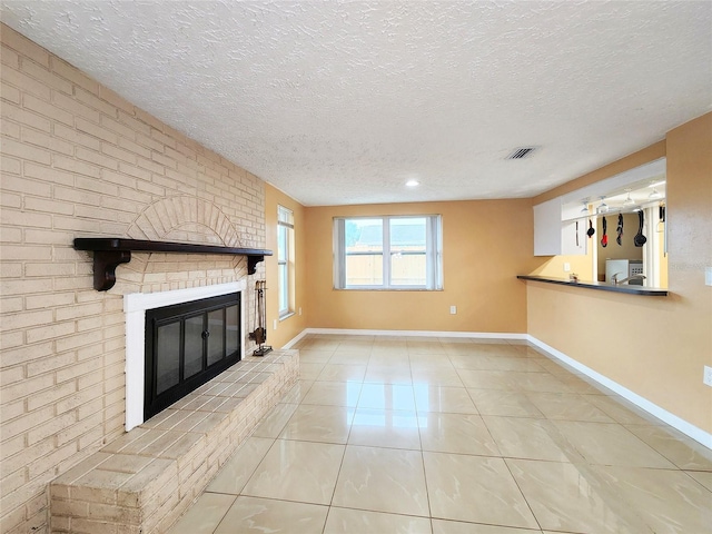 unfurnished living room with light tile patterned floors, a fireplace, visible vents, and baseboards