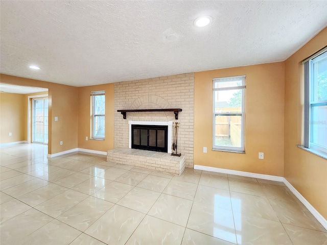 unfurnished living room featuring light tile patterned floors, a fireplace, baseboards, and a textured ceiling