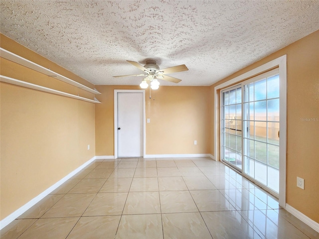 empty room with light tile patterned floors, ceiling fan, baseboards, and a textured ceiling