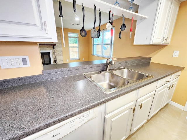 kitchen featuring dark countertops, white cabinets, and dishwasher