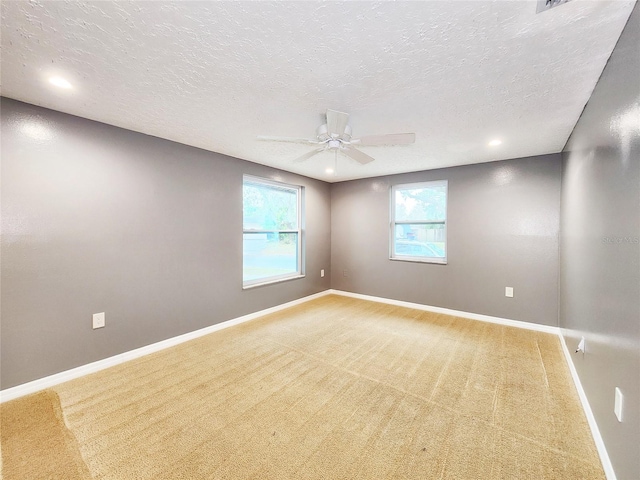 carpeted empty room featuring ceiling fan, a textured ceiling, recessed lighting, and baseboards