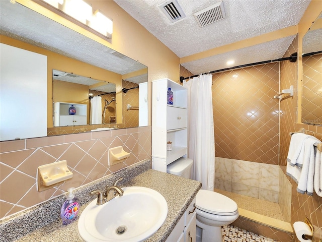 bathroom featuring visible vents, a textured ceiling, and tiled shower