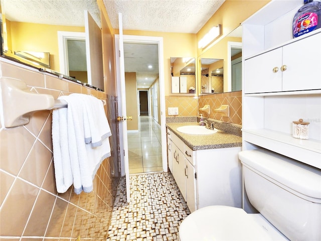 bathroom with tasteful backsplash, toilet, vanity, a textured ceiling, and tile patterned flooring