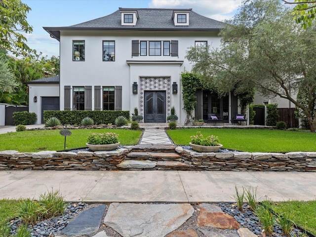 view of front of house with a garage, a front lawn, and french doors