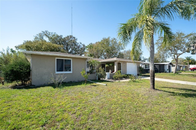 ranch-style house featuring a garage and a front lawn