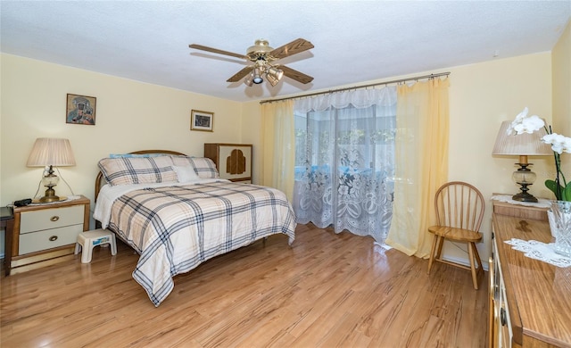 bedroom with ceiling fan, a textured ceiling, and light wood-type flooring