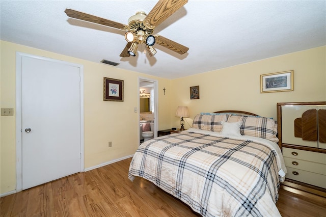 bedroom with wood-type flooring, ceiling fan, and ensuite bathroom