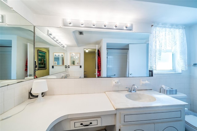 bathroom featuring tasteful backsplash, vanity, and toilet