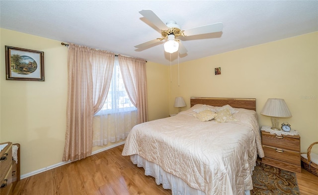 bedroom with light hardwood / wood-style floors and ceiling fan