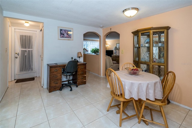 tiled dining room with a textured ceiling