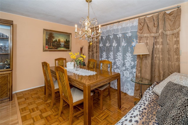 dining space with light parquet floors, a chandelier, and a textured ceiling