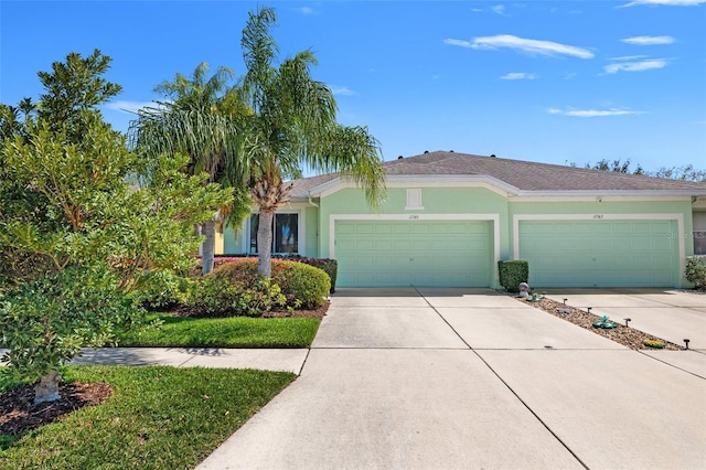 ranch-style home with a garage, driveway, and stucco siding