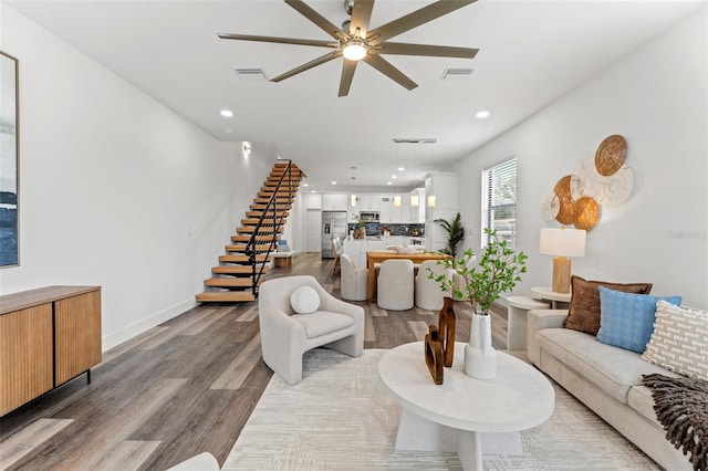 6207 64th Way N, Pinellas Park, FL 33781 - living room featuring light wood finished floors, a ceiling fan, stairway, recessed lighting, and baseboards