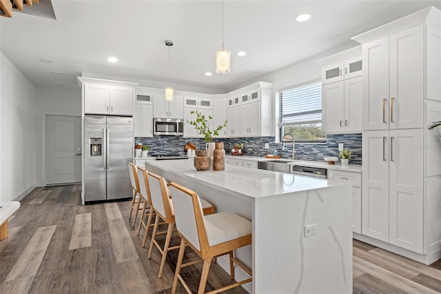 6207 64th Way N, Pinellas Park, FL 33781 - kitchen with stainless steel appliances, a sink, backsplash, light wood finished floors, and a kitchen island