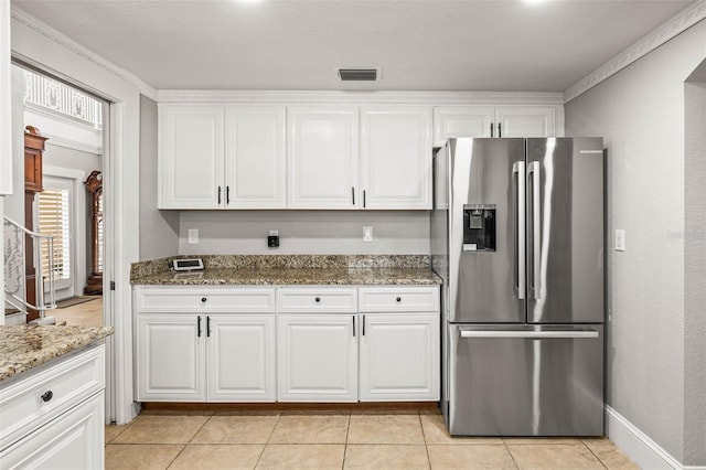 kitchen featuring stone counters, stainless steel fridge with ice dispenser, and white cabinets