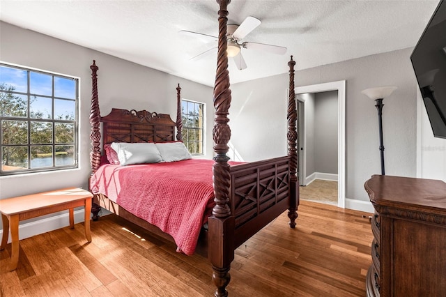 bedroom featuring hardwood / wood-style flooring, a textured ceiling, and ceiling fan