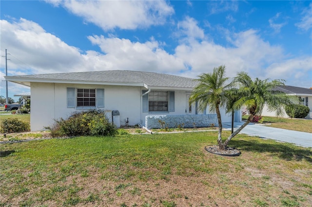 single story home with a shingled roof, a front lawn, concrete driveway, and stucco siding