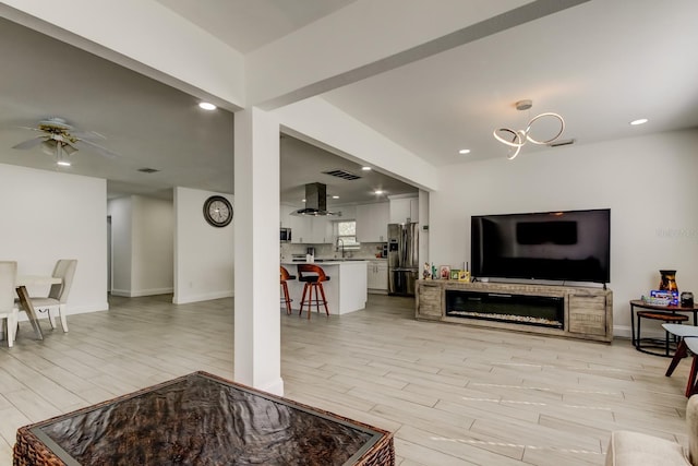 living area featuring recessed lighting, visible vents, baseboards, a ceiling fan, and light wood-style floors