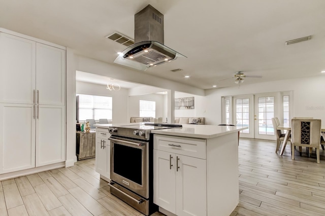 kitchen featuring white cabinets, a ceiling fan, wood tiled floor, stainless steel electric range, and island exhaust hood