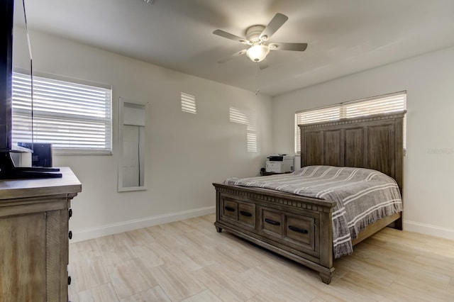 bedroom with light wood-type flooring, baseboards, and a ceiling fan