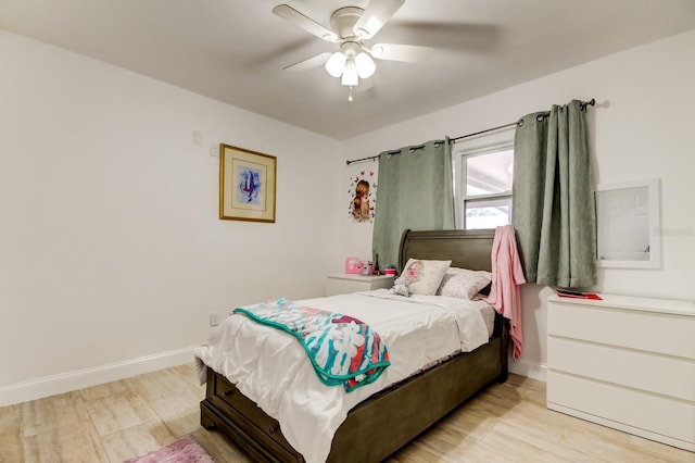 bedroom with light wood-style flooring, baseboards, and a ceiling fan