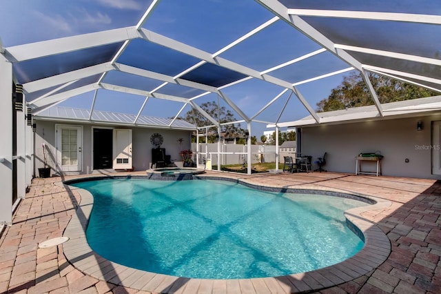 view of pool featuring a lanai, a pool with connected hot tub, fence, and a patio