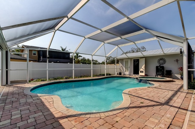 view of pool with glass enclosure, a patio area, a pool with connected hot tub, and fence