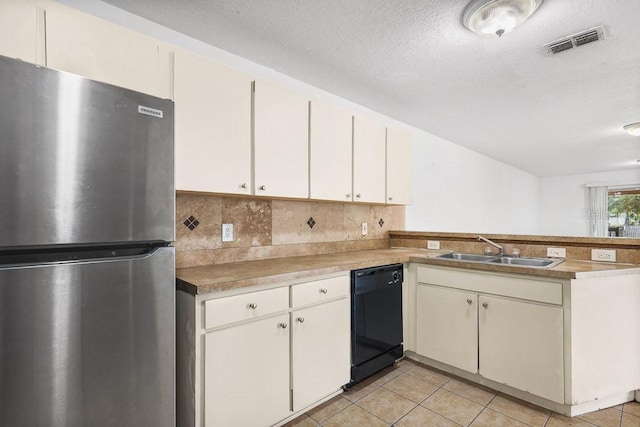 kitchen featuring stainless steel fridge, black dishwasher, sink, and light tile patterned floors