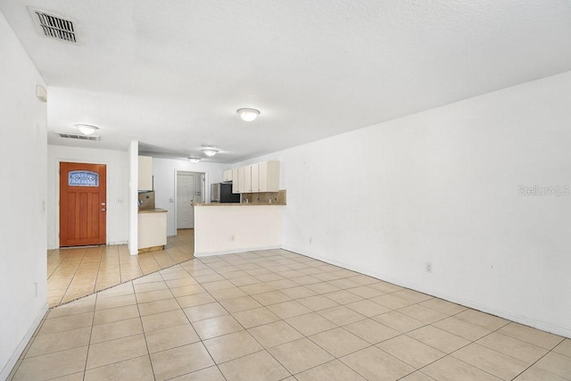 unfurnished living room with light tile patterned floors