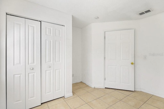 unfurnished bedroom with light tile patterned floors and a closet