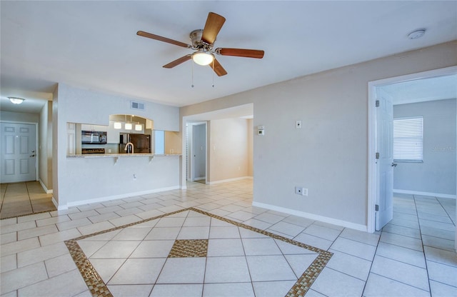 unfurnished living room featuring ceiling fan and light tile patterned flooring