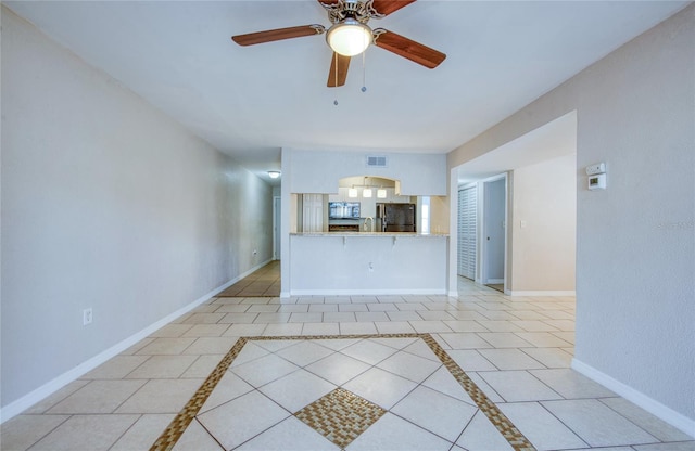 unfurnished living room featuring ceiling fan and light tile patterned floors