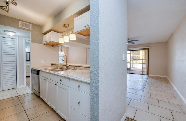 kitchen with pendant lighting, sink, white cabinets, stainless steel dishwasher, and light tile patterned floors