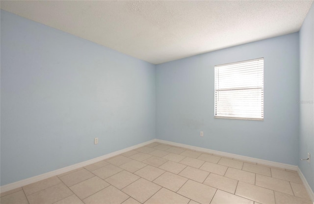 unfurnished room featuring light tile patterned floors and a textured ceiling