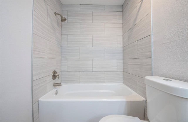 bathroom with toilet and tiled shower / bath combo