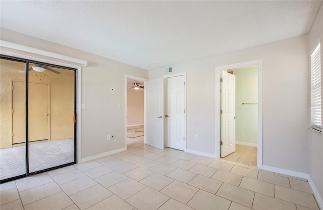 unfurnished bedroom with a closet, a textured ceiling, and light tile patterned floors