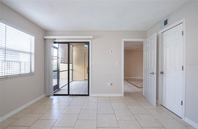 tiled spare room with a textured ceiling