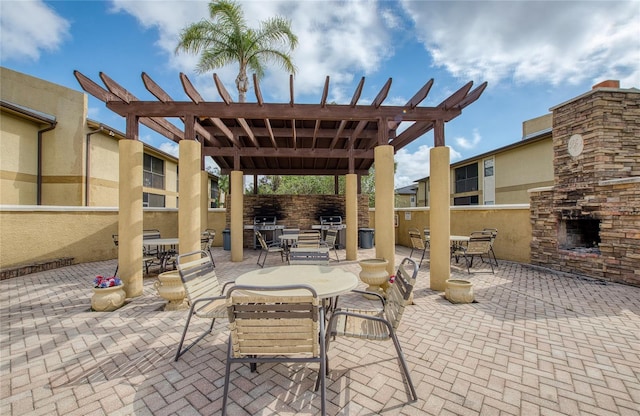 view of patio featuring a stone fireplace and a pergola