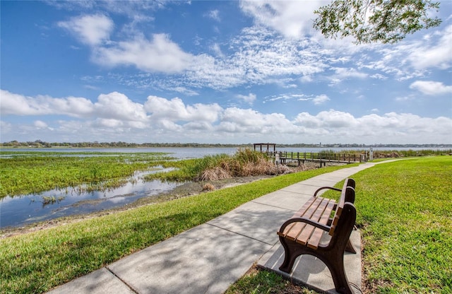 surrounding community featuring a water view and a lawn