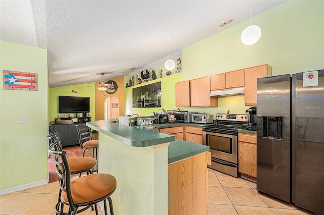 kitchen with pendant lighting, light tile patterned flooring, a kitchen breakfast bar, and appliances with stainless steel finishes