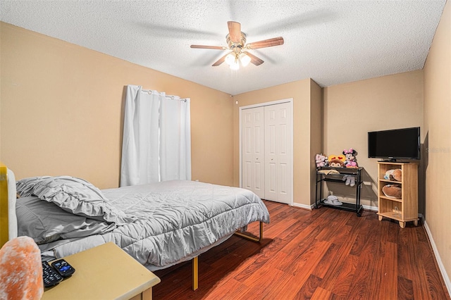 bedroom with ceiling fan, dark hardwood / wood-style floors, a textured ceiling, and a closet