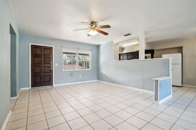 unfurnished living room featuring ceiling fan and light tile patterned floors