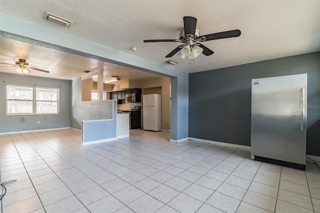 kitchen with ceiling fan, appliances with stainless steel finishes, a textured ceiling, light tile patterned flooring, and kitchen peninsula