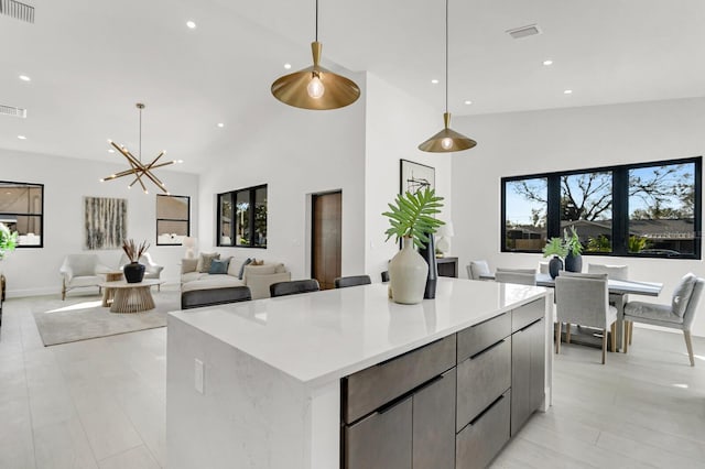 kitchen featuring a spacious island, an inviting chandelier, decorative light fixtures, and high vaulted ceiling