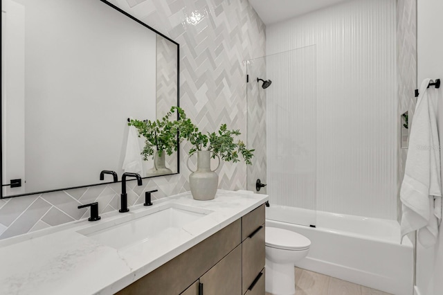 full bathroom featuring vanity, backsplash, toilet, and tiled shower / bath