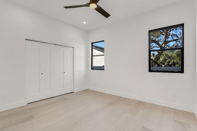 unfurnished bedroom featuring light hardwood / wood-style floors, a closet, and ceiling fan