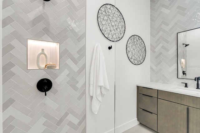 bathroom with tiled shower and vanity